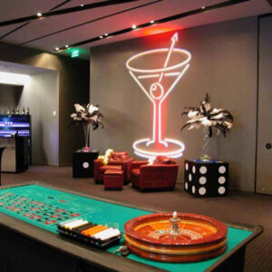 A casino room with a roule table and a cocktail bar.