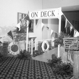 A black and white photo of a room with a sign that says on deck.