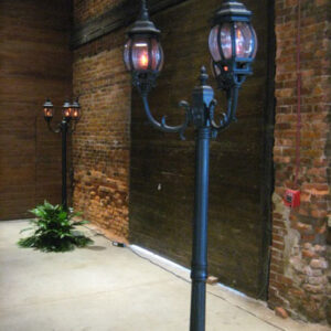 Two street lamps in front of a brick building.