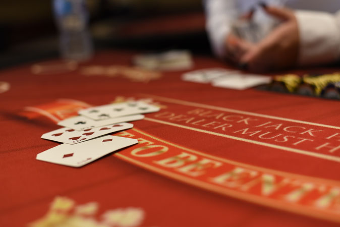 A person is playing blackjack on a casino table.