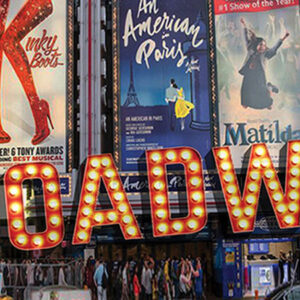 Broadway sign in front of a building in times square.