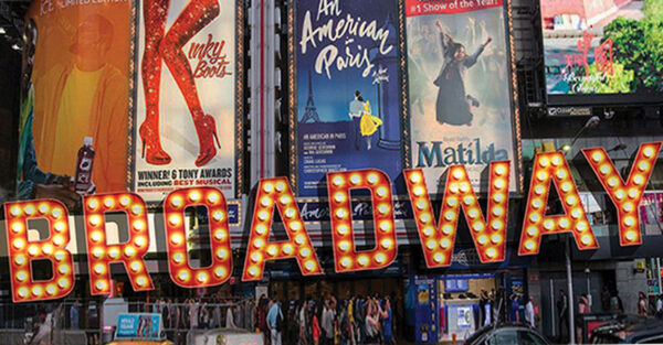 Broadway sign in front of a building in times square.