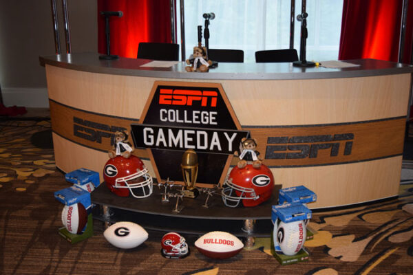 A table with footballs and helmets on it.