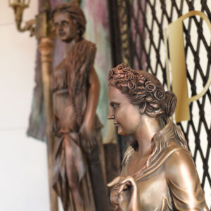 Bronze statues of a woman and a man on a wall.