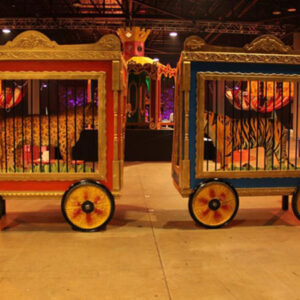 Two animal cages in a circus tent.