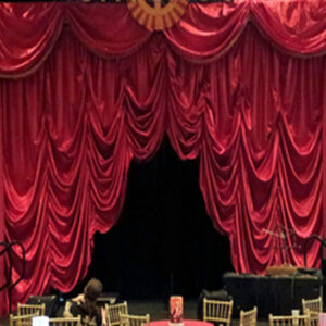 A stage with an Austrian Venetian Drape curtain and tables.