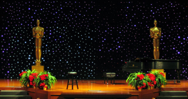 Art Deco Backdrop statues on a stage with a piano.