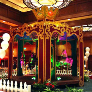 A Large Carousel in the middle of a room with balloons.