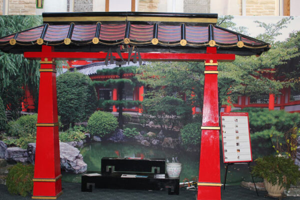 A red and gold Large Tori Gate with a bench in front of it.