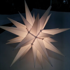 A white Hanging Star shaped lamp on a table.