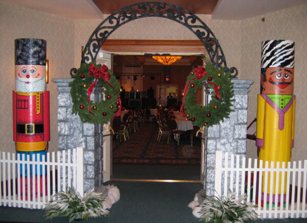 Two Circular Nutcrackers standing in front of a white picket.