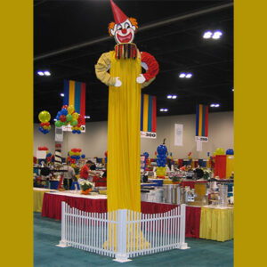 A Tall Clown standing on a pole.