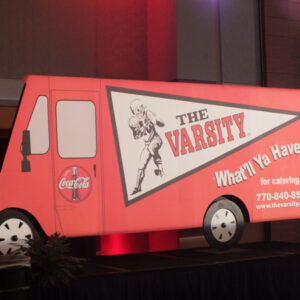 A coca cola truck is on display at a convention.