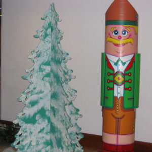 A Circular Nutcracker statue next to a christmas tree.