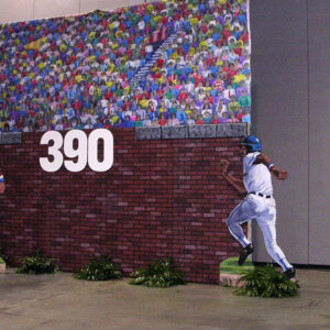 A brick wall with Baseball Outfield players on it.