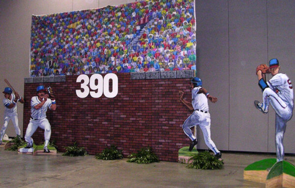 A brick wall with Baseball Outfield players on it.