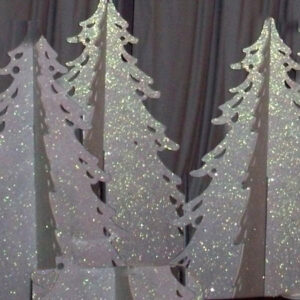 A group of White Slotted Christmas Trees with glitter on them.