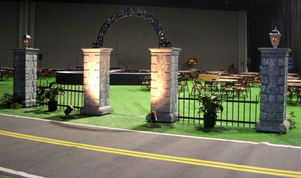 A stone Gates in the middle of a green field.