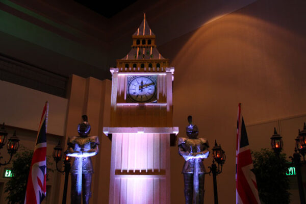 Big Ben is a clock tower with two statues on top of it.