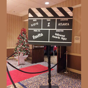 A Custom Clapboard in front of a christmas tree.