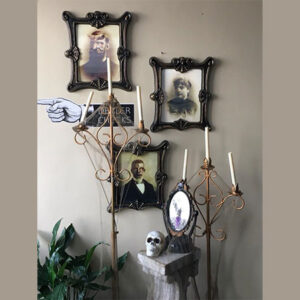 A group of 3D Zombie Portraits and a skull on a wall.