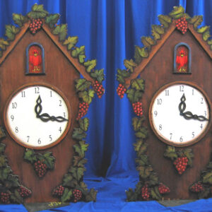 Two wooden Cuckoo Clocks with berries on them.