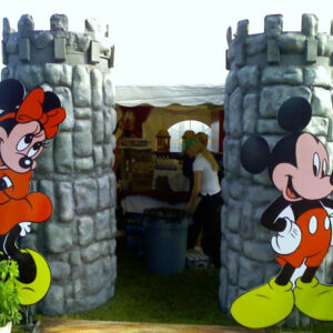 Mickey mouse and minnie mouse standing in front of a castle.