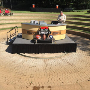 A man is standing on a sports desk in a park.