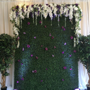 A Pallet Wood Wall decorated with flowers and greenery.