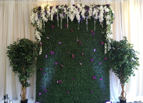 A Pallet Wood Wall decorated with flowers and greenery.