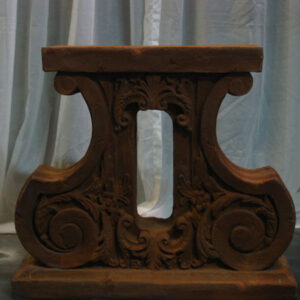 An ornately carved Decorative Pedestal on a table.