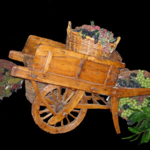 A wooden goat cart with grapes on it.