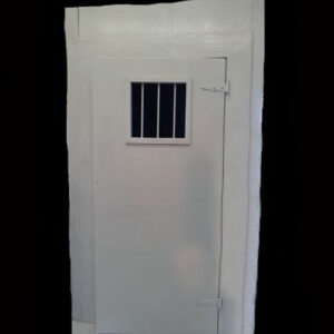 A white Jail Cell door with bars on it.