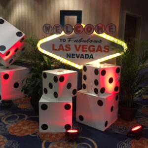 A Welcome to Vegas Sign with dice in front of it.