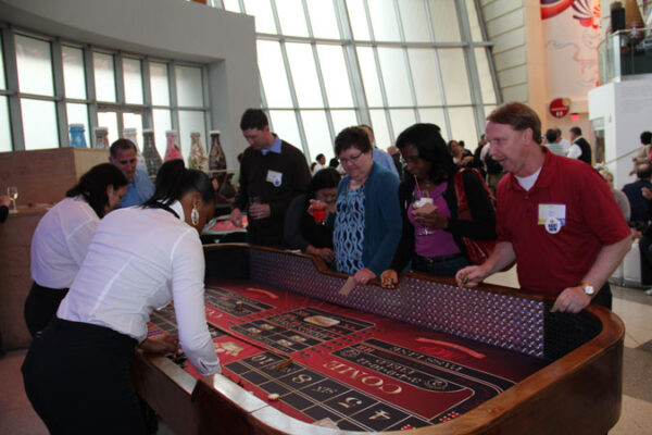 A group of people playing a game of craps tables.