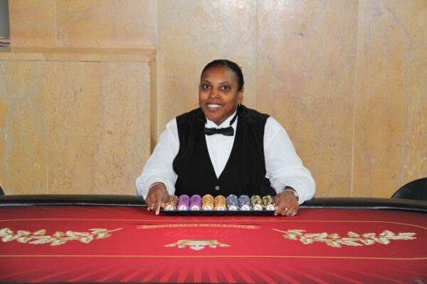 A woman sitting at a Texas Hold'em Tables.