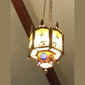 A Medieval Lamp hanging from a ceiling in a church.