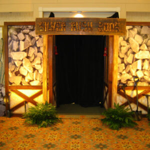 A doorway with a black curtain and rocks on the wall.