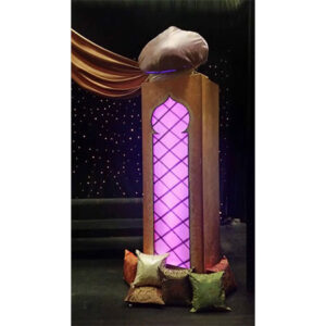 Moroccan Columns - A wooden stand with a purple light on it.