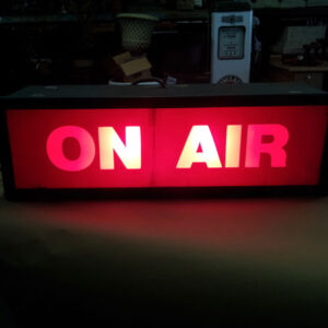 A red On Air Sign on a table.