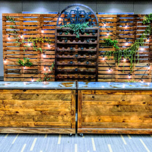 An Outdoor Bar and Pallet Wood Wall with plants on it.