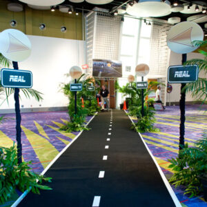 A walkway with palm trees and plants in front of it.