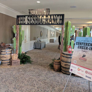 The entrance to a convention hall with barrels and cactus signs.