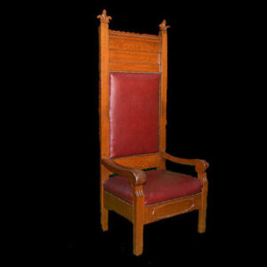 A wooden Baby Throne chair with a red leather seat.