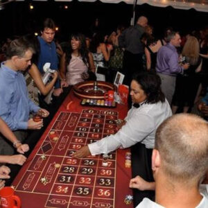 A group of people playing roulette tables at a party.