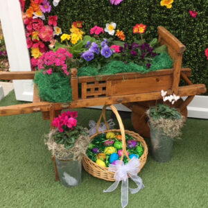 A Flower Carts filled with flowers and easter eggs.