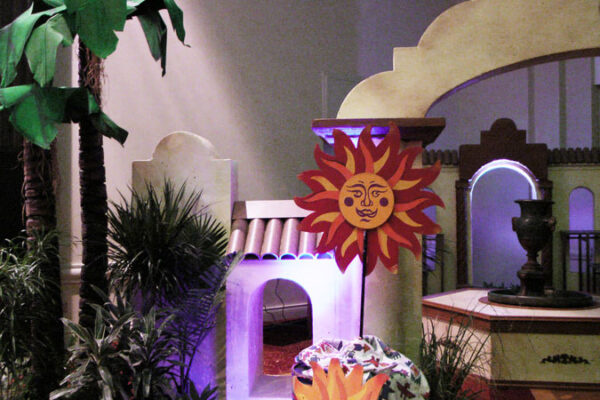 A toy house with Smiling Suns and a tree.