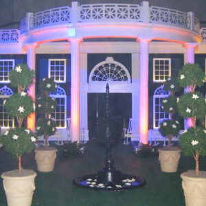 A Southern Mansion and Garden is lit up at night.