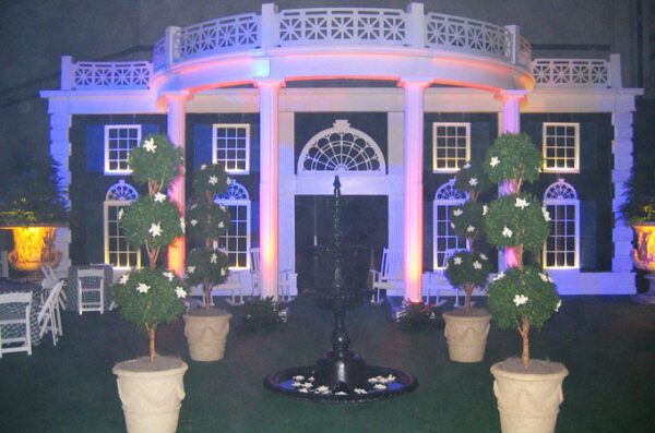 A Southern Mansion and Garden is lit up at night.