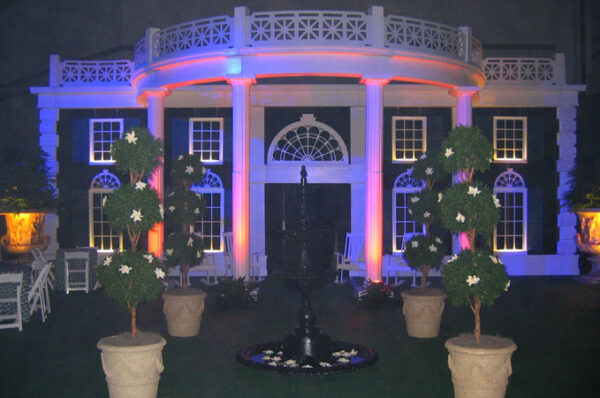 A white house is lit up with blue and white lights.